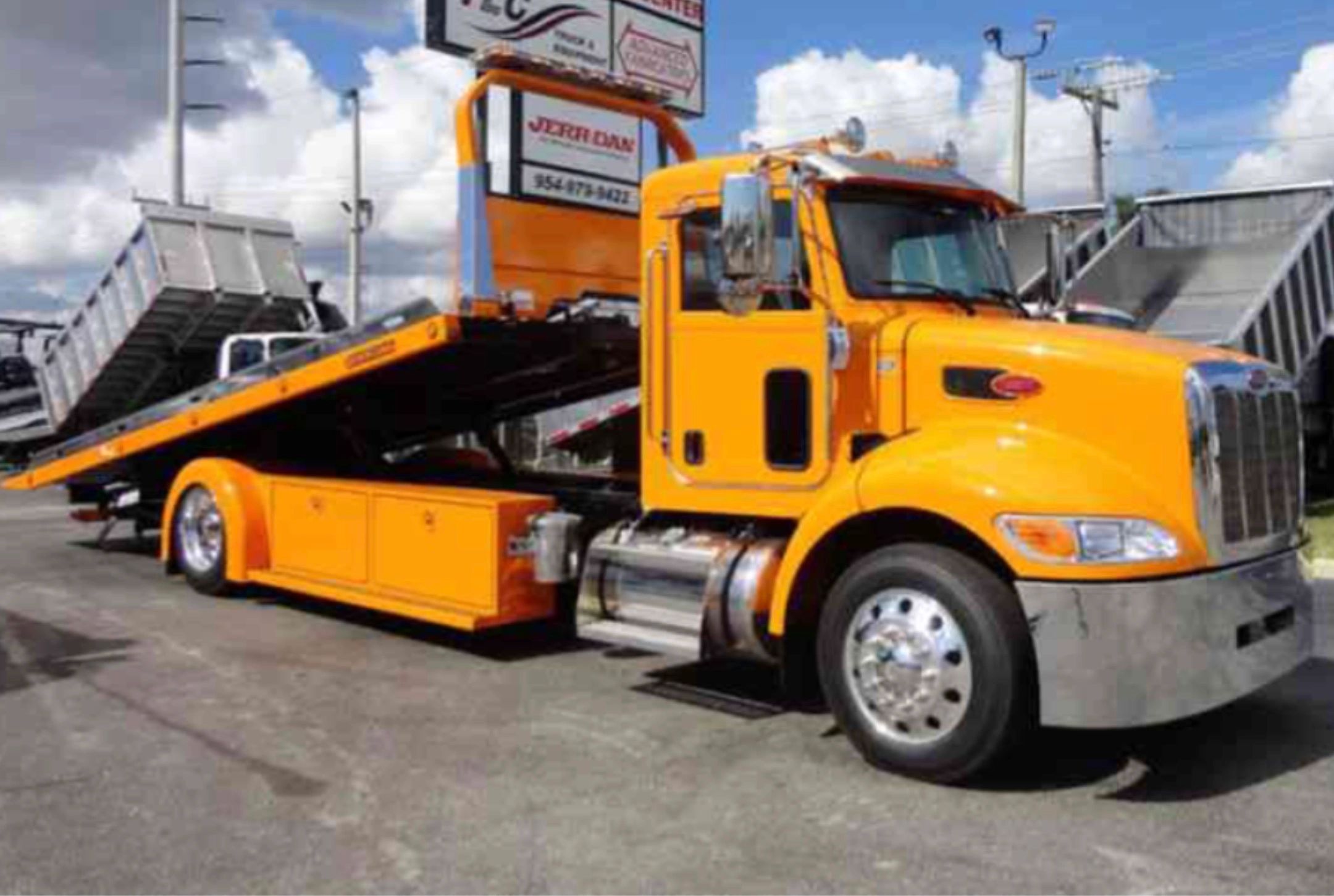Reliable Towing & Recovery orange Peterbilt rollback flatbed tow truck